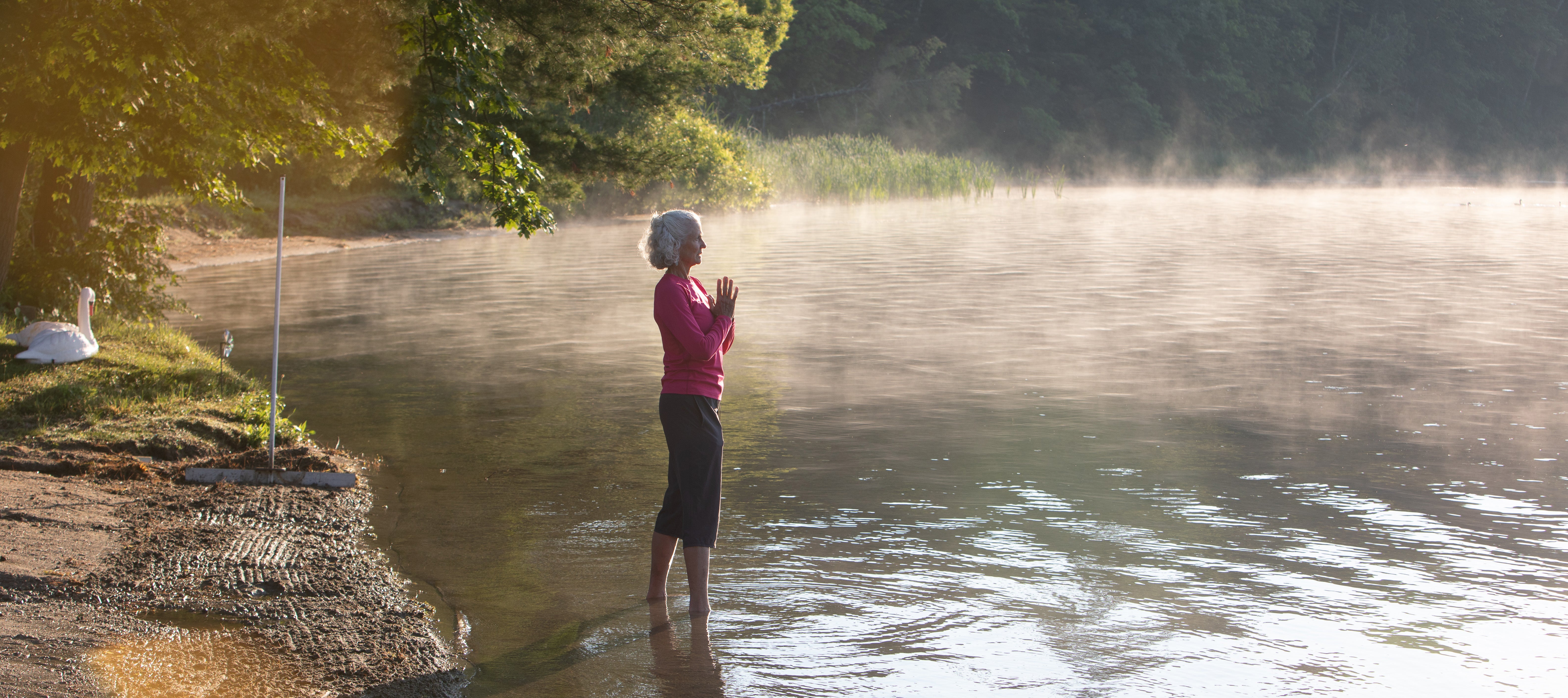Aging Gratefully A woman with white hair standing in Lake Mahkeenac