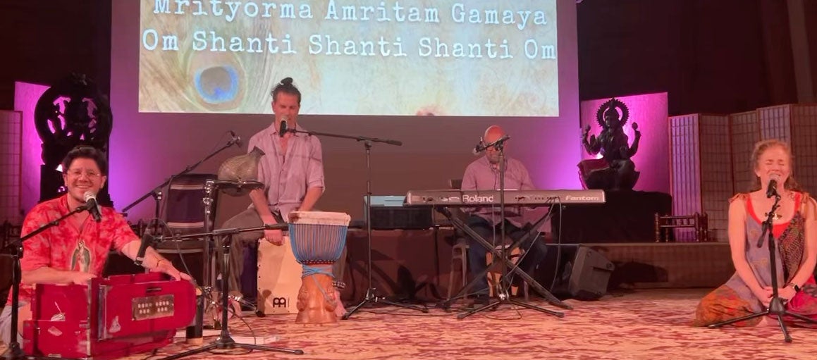 Miles Borrero leading chanting with three other musicians