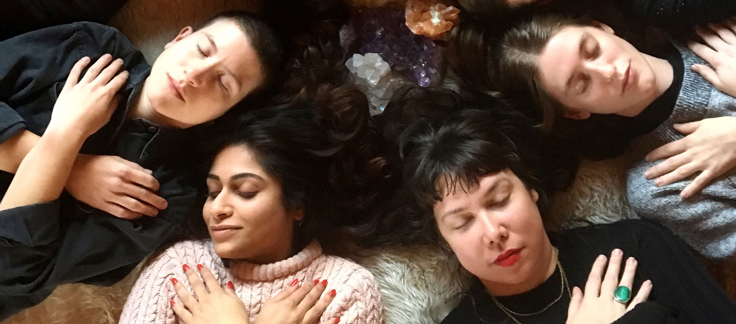 group of people lying down with eyes closed and arms crossed over their chest