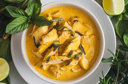 A photo of a bowl of yellow curry with chicken
