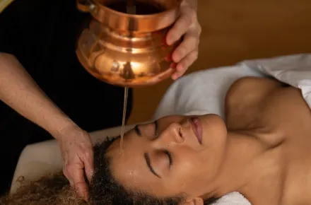 Woman receiving Ayurvedic oil treatment