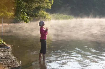 A woman with white hair standing in Lake Mahkeenac
