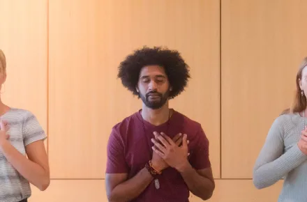 three people with hands over heart
