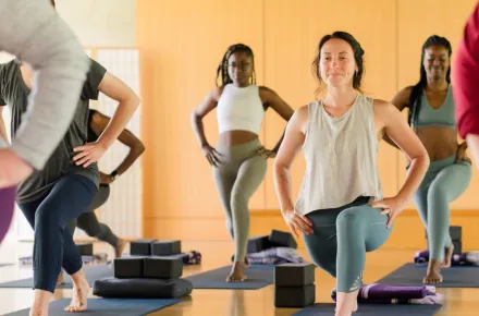 women in yoga class doing lunge pose