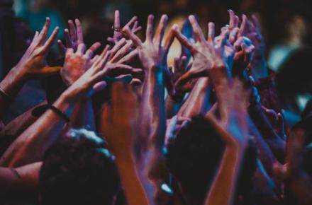 Group of people indoors with hands raised