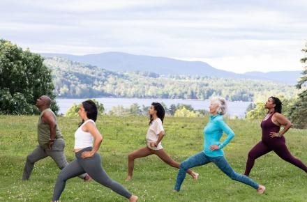five people doing yoga outside
