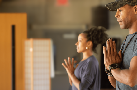 Two people of color practicing yoga and meditating