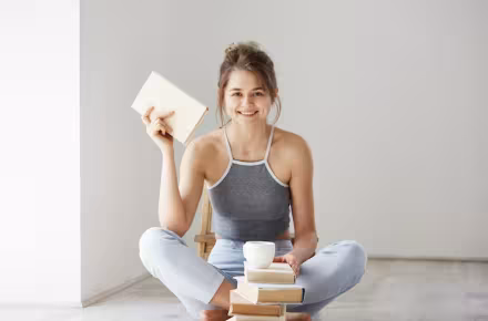 Young beautiful woman smiling and holding a book