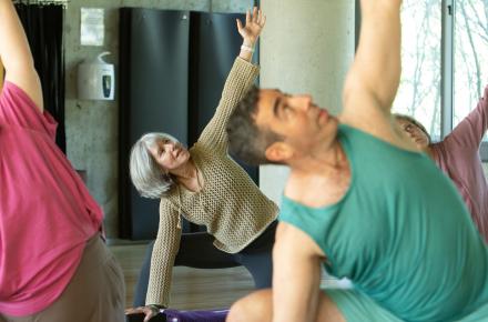 Group of people practicing active yoga indoors