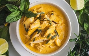 A photo of a bowl of yellow curry with chicken