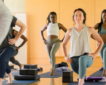 women in yoga class doing lunge pose