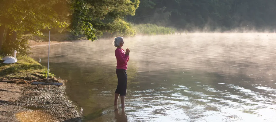 A woman with white hair standing in Lake Mahkeenac