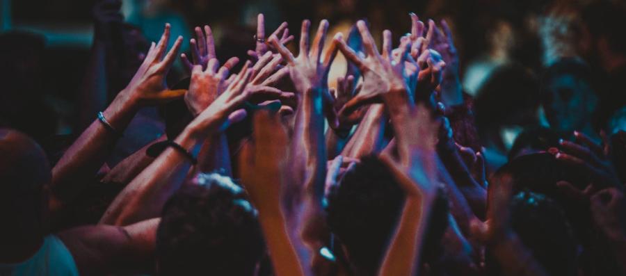 Group of people indoors with hands raised