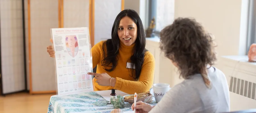 A woman provides an ayurvedic consultation to a client