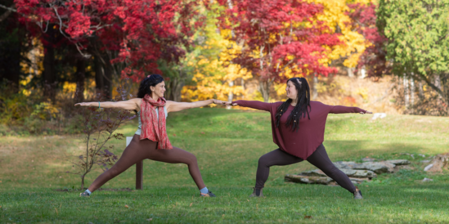 two people doing yoga outside