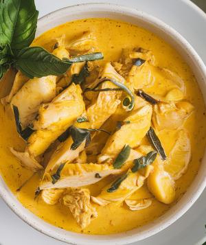 A photo of a bowl of yellow curry with chicken