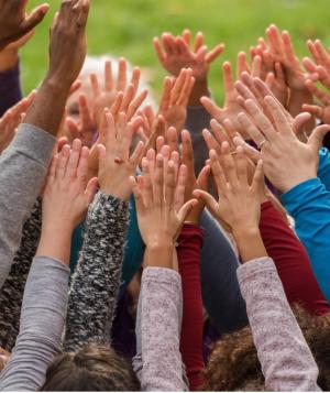Group of people with hands raised.