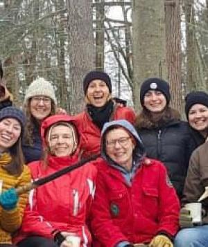 Group of smiling, exuberant people triumphant in the winter woods