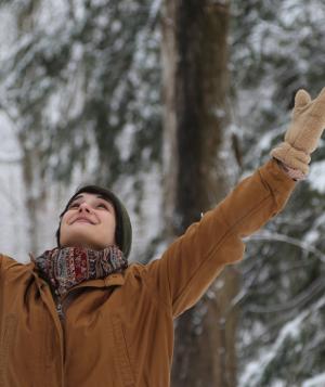 Woman with arms raised in the forest in the winter