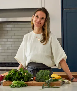 Photo of Nicki Sizemore in a kitchen preparing vegetables.