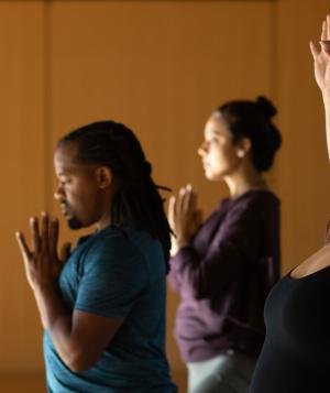 three yoga students with eyes closed
