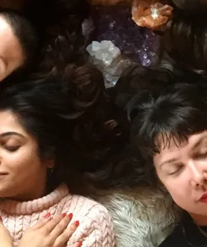 group of people lying down with eyes closed and arms crossed over their chest