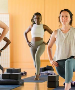 women in yoga class doing lunge pose
