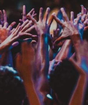 Group of people indoors with hands raised