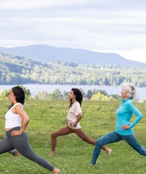 five people doing yoga outside