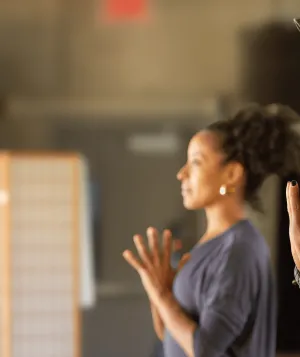 Two people of color practicing yoga and meditating